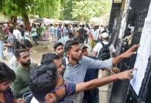 Students checking entry guidelines and CUET UG 2026 revised timings at an examination center.